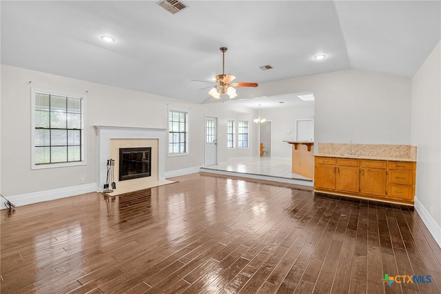 unfurnished living room featuring a wealth of natural light, dark hardwood / wood-style floors, and vaulted ceiling