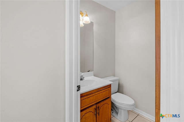 bathroom with toilet, vanity, and tile patterned flooring