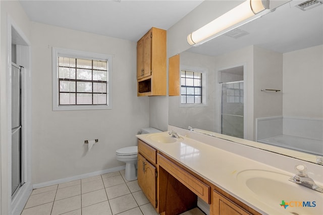 bathroom featuring toilet, a healthy amount of sunlight, tile patterned floors, and a shower with door