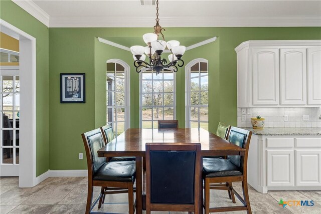 dining area featuring ornamental molding, baseboards, a notable chandelier, and light tile patterned floors