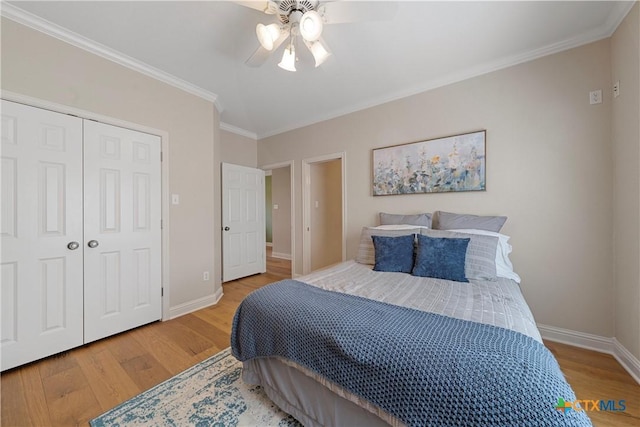 bedroom with wood finished floors, a ceiling fan, a closet, crown molding, and baseboards