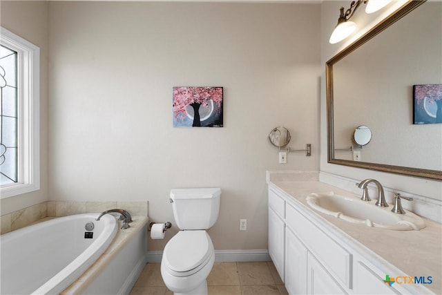 bathroom featuring a garden tub, vanity, baseboards, toilet, and tile patterned flooring