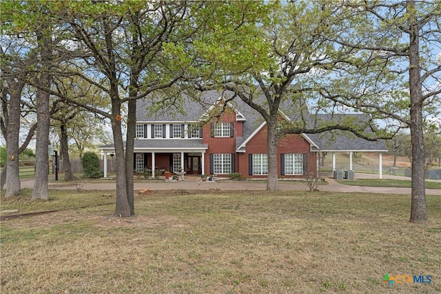 view of front facade with covered porch, a front lawn, and central AC unit
