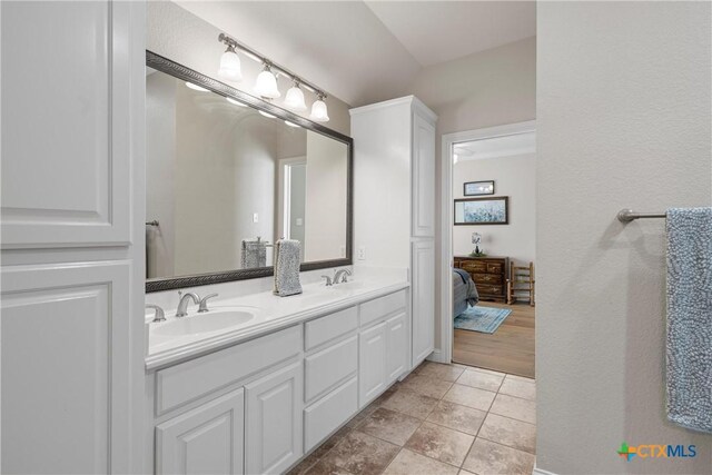 full bathroom featuring double vanity, tile patterned flooring, and a sink