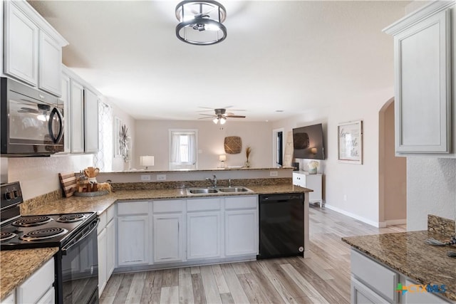 kitchen with white cabinetry, sink, black appliances, and light hardwood / wood-style floors