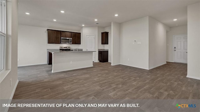 kitchen with hardwood / wood-style floors, dark brown cabinets, stainless steel appliances, and a center island with sink