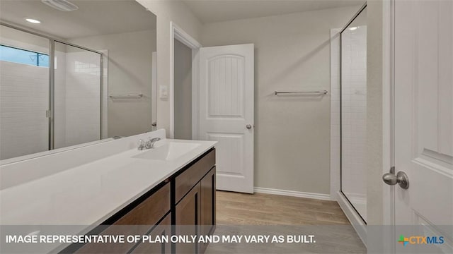 bathroom with hardwood / wood-style flooring, vanity, and an enclosed shower