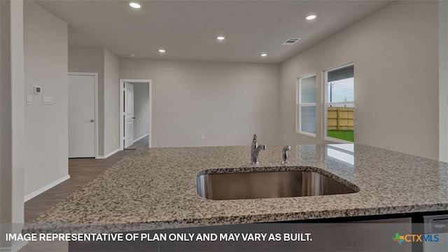 kitchen featuring dark hardwood / wood-style flooring, sink, and light stone counters