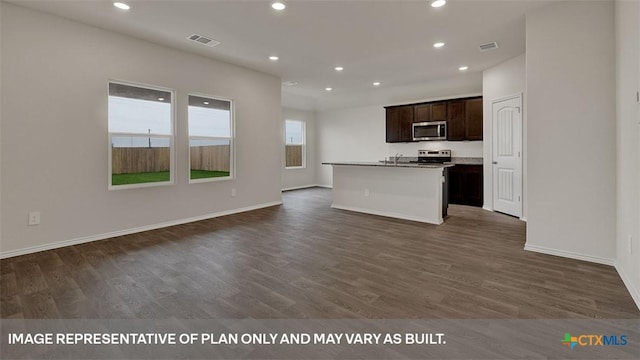 kitchen featuring sink, dark wood-type flooring, appliances with stainless steel finishes, dark brown cabinetry, and an island with sink