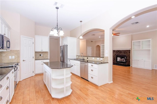1935 Grandview Dr, Salado, TX 76571 - kitchen featuring appliances with stainless steel finishes, open shelves, tasteful backsplash, white cabinetry, and decorative light fixtures