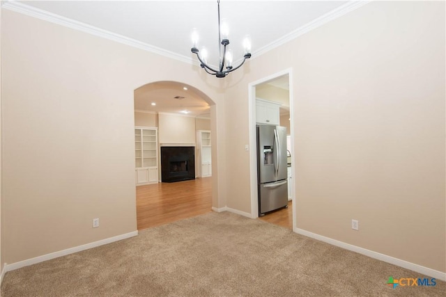 1935 Grandview Dr, Salado, TX 76571 - spare room featuring light carpet, arched walkways, ornamental molding, a chandelier, and a fireplace