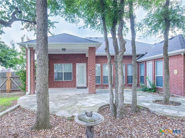 1935 Grandview Dr, Salado, TX 76571 - back of house with a patio area, brick siding, and a shingled roof