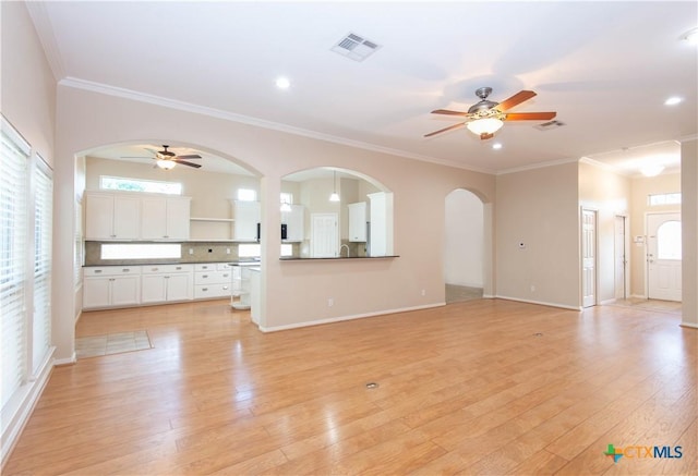 1935 Grandview Dr, Salado, TX 76571 - unfurnished living room featuring a ceiling fan, light wood-style floors, ornamental molding, recessed lighting, and arched walkways