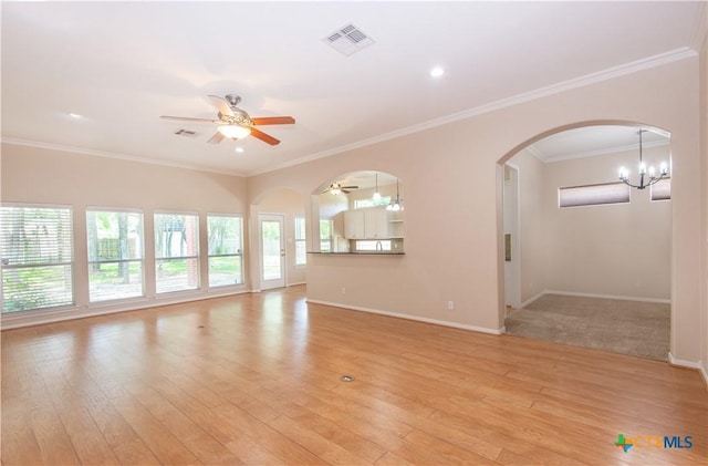 1935 Grandview Dr, Salado, TX 76571 - unfurnished living room with ceiling fan, light wood-type flooring, arched walkways, ornamental molding, and a chandelier