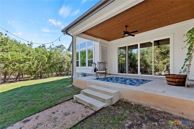 exterior space featuring ceiling fan and a yard