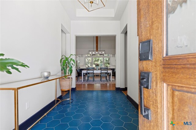 foyer with dark wood-type flooring and an inviting chandelier