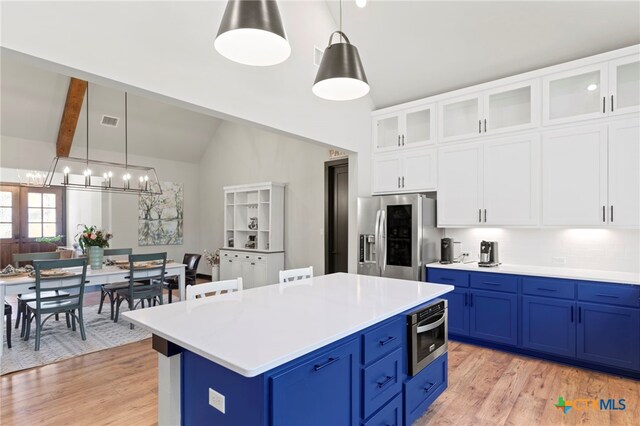 kitchen featuring white cabinets, vaulted ceiling with beams, hanging light fixtures, and appliances with stainless steel finishes