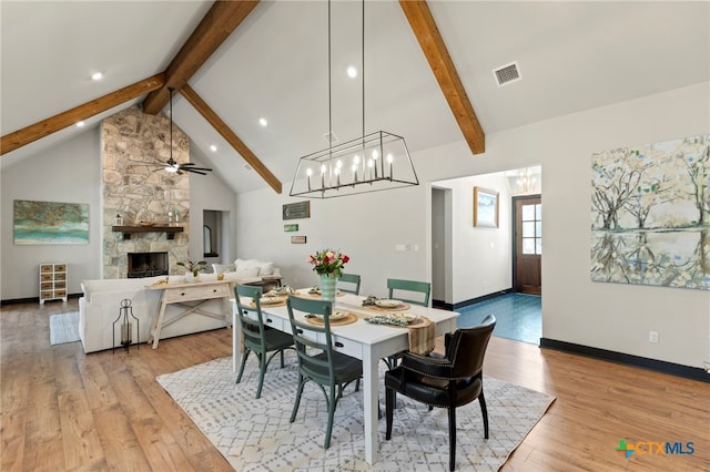 dining room with a fireplace, lofted ceiling with beams, light hardwood / wood-style flooring, and ceiling fan