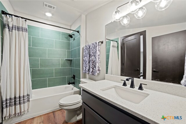 full bathroom with wood-type flooring, vanity, toilet, and shower / bathtub combination with curtain