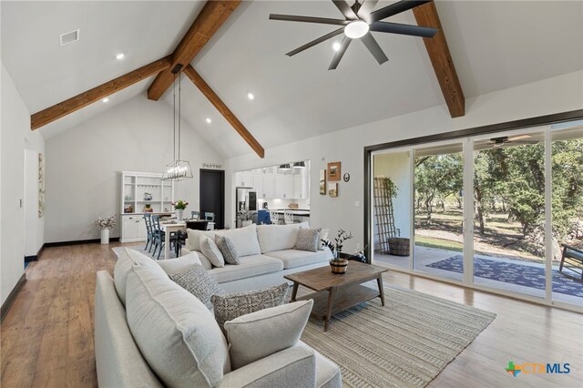 living room with beamed ceiling, high vaulted ceiling, and light hardwood / wood-style flooring