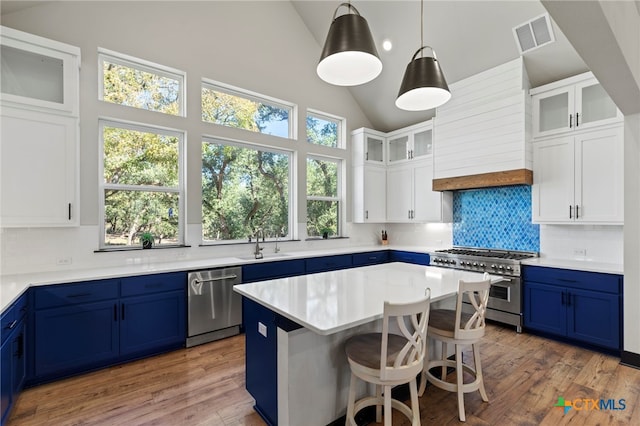 kitchen with white cabinetry, a kitchen island, blue cabinets, and appliances with stainless steel finishes