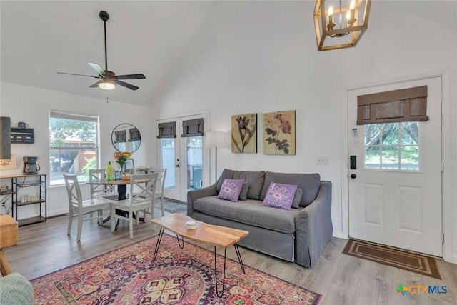 living area featuring french doors, high vaulted ceiling, a ceiling fan, and wood finished floors