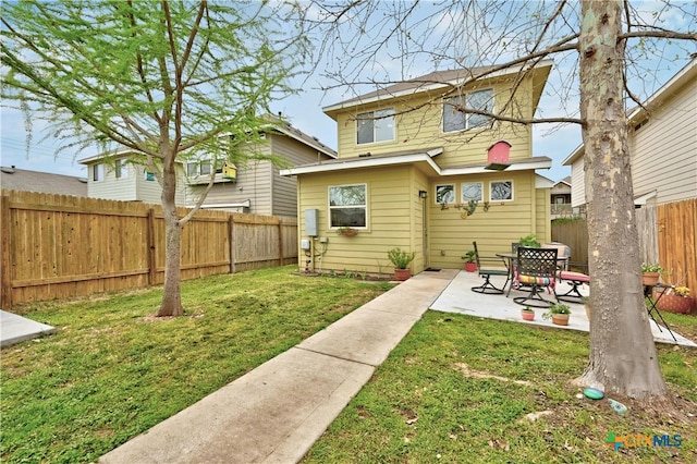 back of property featuring a yard, a fenced backyard, and a patio