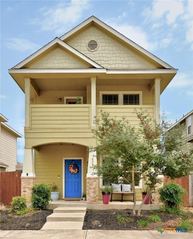 view of front of house featuring a porch, fence, and a balcony