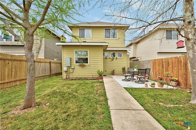 back of house with a patio, a yard, and a fenced backyard