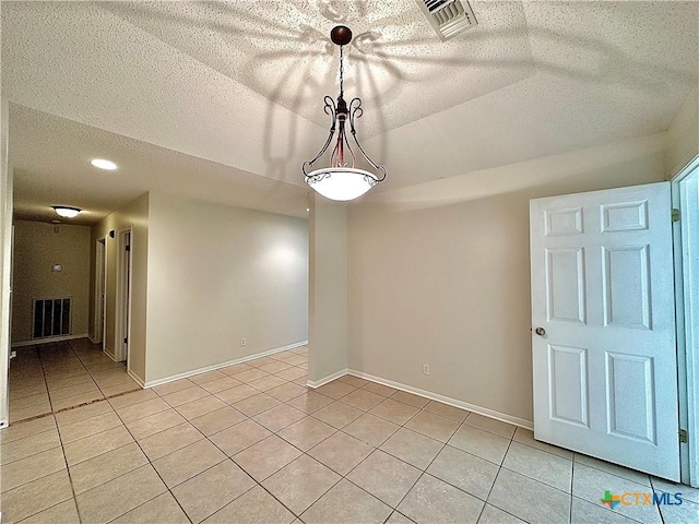 unfurnished room with light tile patterned floors and a textured ceiling