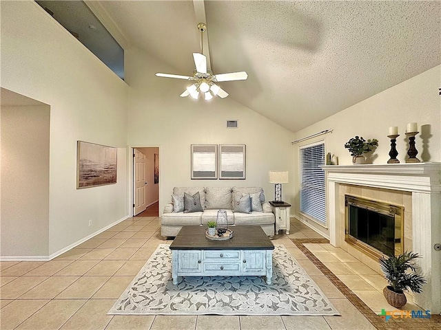 110 Ashford Dr, Victoria, TX 77904 - living room featuring light tile patterned floors, baseboards, a fireplace, ceiling fan, and a textured ceiling
