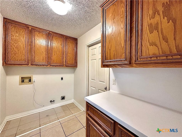 laundry area with cabinets, hookup for a washing machine, electric dryer hookup, light tile patterned floors, and hookup for a gas dryer