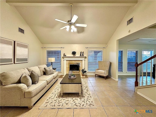 living room with light tile patterned flooring, visible vents, baseboards, and a ceiling fan