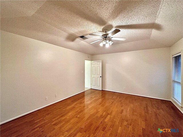 empty room featuring ceiling fan, wood-type flooring, and a textured ceiling