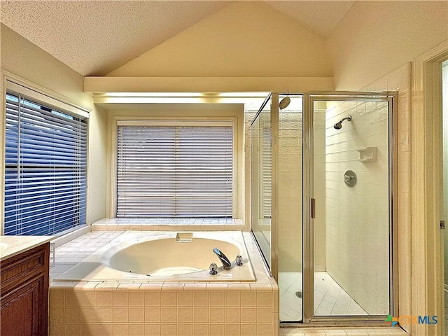 bathroom with vanity, lofted ceiling, a textured ceiling, and plus walk in shower