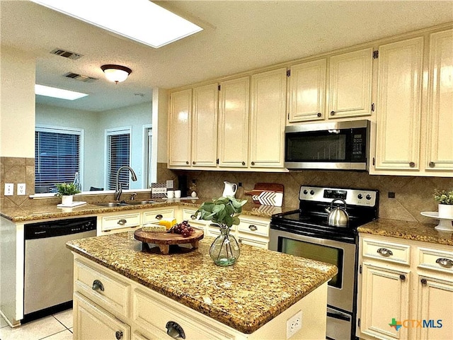 110 Ashford Dr, Victoria, TX 77904 - kitchen with visible vents, a sink, a kitchen island, tasteful backsplash, and stainless steel appliances
