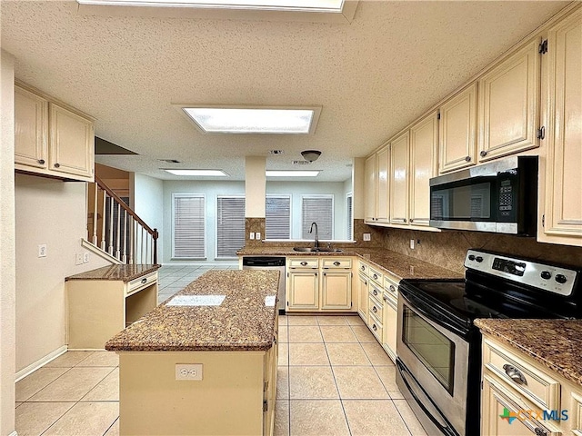 kitchen featuring a center island, sink, a textured ceiling, appliances with stainless steel finishes, and stone countertops