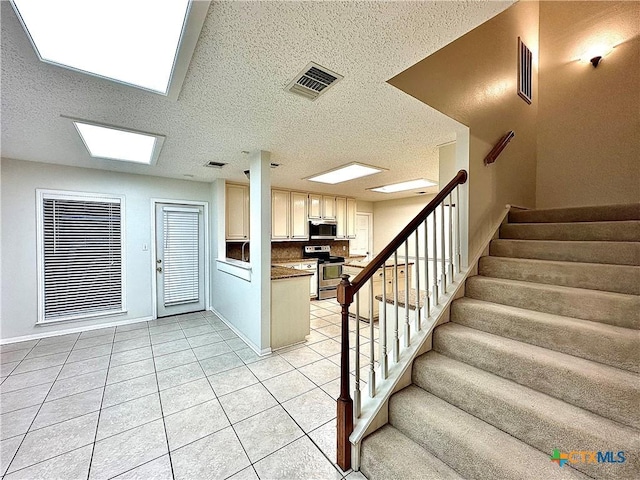 stairway with tile patterned floors and a textured ceiling