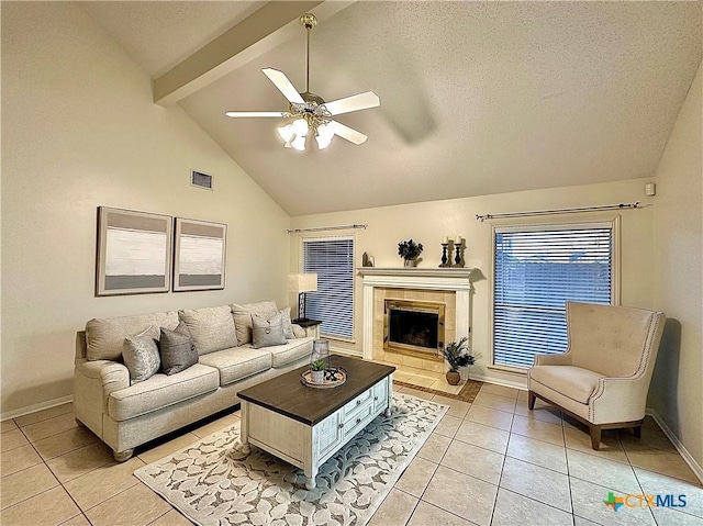 110 Ashford Dr, Victoria, TX 77904 - living room featuring visible vents, a tiled fireplace, beamed ceiling, light tile patterned floors, and a ceiling fan
