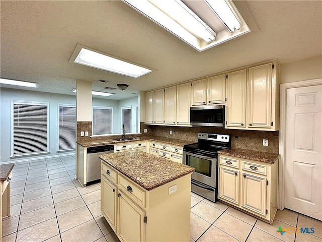 kitchen featuring cream cabinets, a center island, and stainless steel appliances