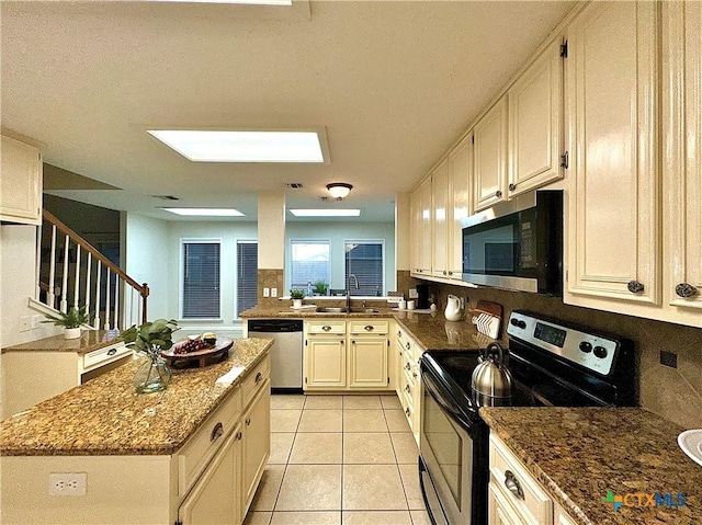 110 Ashford Dr, Victoria, TX 77904 - kitchen with a center island, dark stone counters, light tile patterned floors, stainless steel appliances, and a sink
