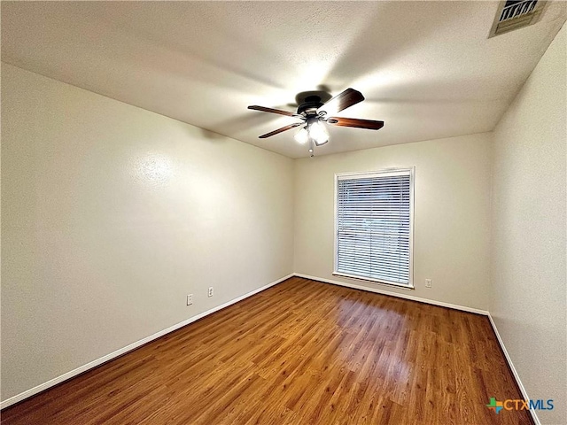 empty room with hardwood / wood-style floors, ceiling fan, and a textured ceiling