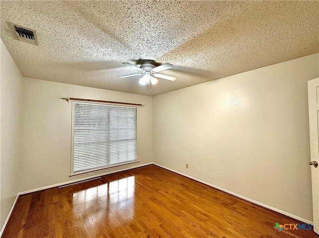 empty room with hardwood / wood-style floors, a textured ceiling, and ceiling fan