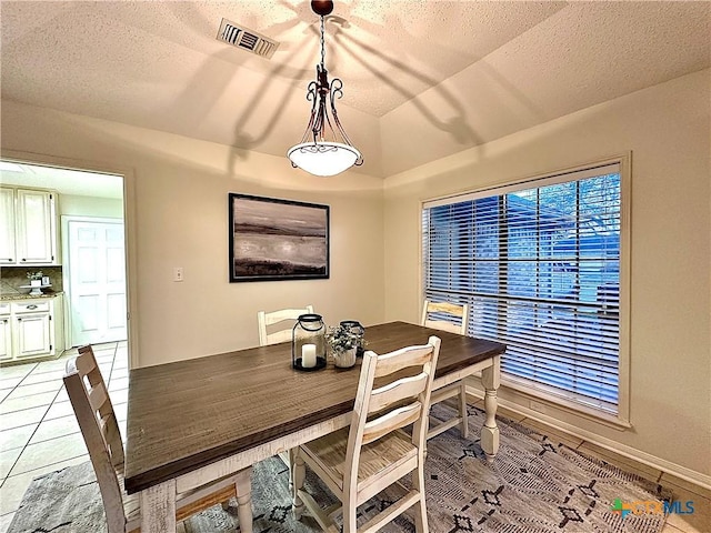110 Ashford Dr, Victoria, TX 77904 - dining room with light tile patterned floors, baseboards, visible vents, vaulted ceiling, and a textured ceiling