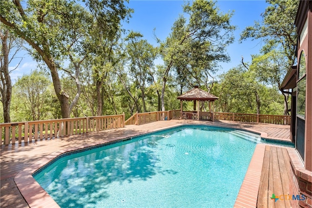 view of pool featuring a wooden deck and a gazebo