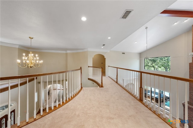 hall with a notable chandelier, light carpet, and crown molding