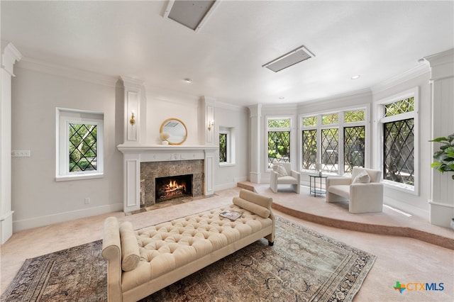 living room with a fireplace, a wealth of natural light, crown molding, and carpet