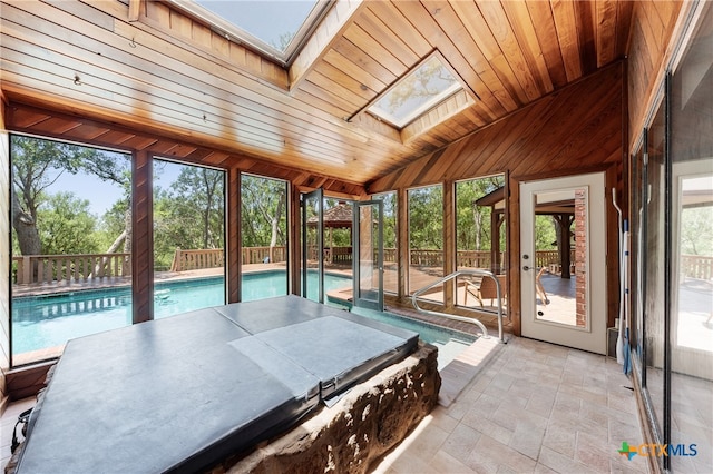 sunroom / solarium featuring lofted ceiling with skylight, wood ceiling, and a healthy amount of sunlight