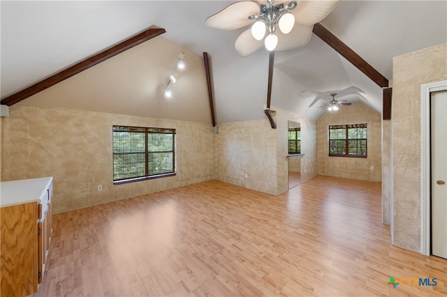 unfurnished living room with light wood-type flooring, ceiling fan, and vaulted ceiling with beams