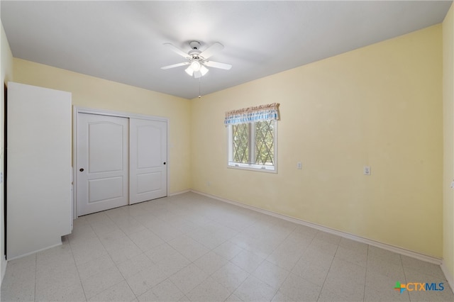 unfurnished bedroom featuring ceiling fan and a closet